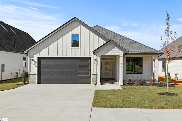 modern farmhouse featuring a garage and a front lawn