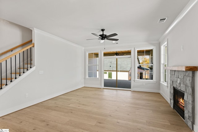 unfurnished living room with ceiling fan, a fireplace, light hardwood / wood-style floors, and ornamental molding