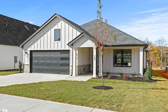 modern farmhouse featuring a front yard and a garage