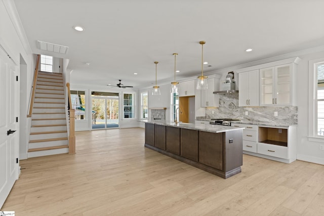 kitchen featuring a healthy amount of sunlight, white cabinets, hanging light fixtures, and ceiling fan