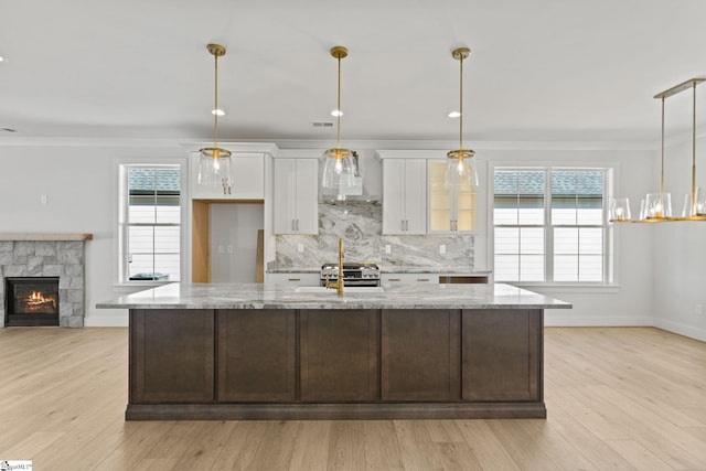 kitchen with light hardwood / wood-style floors, white cabinetry, and light stone counters