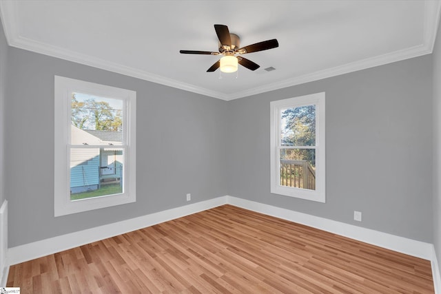 spare room with crown molding, ceiling fan, a healthy amount of sunlight, and light wood-type flooring