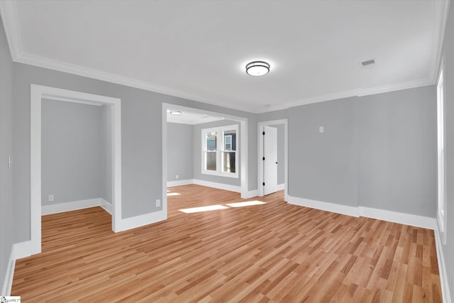 spare room featuring light hardwood / wood-style floors and crown molding