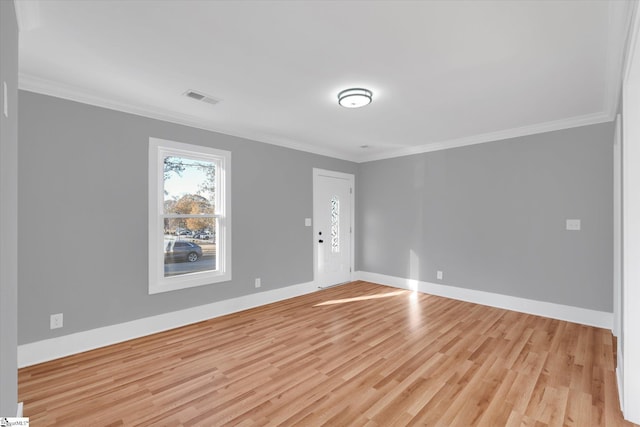 spare room with light hardwood / wood-style flooring and crown molding