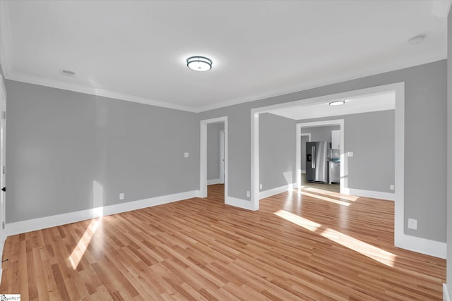 empty room featuring light hardwood / wood-style floors and crown molding