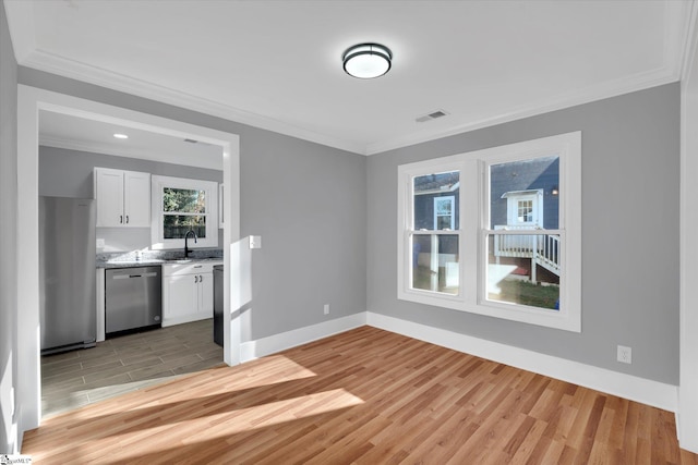 interior space featuring sink, ornamental molding, and light wood-type flooring