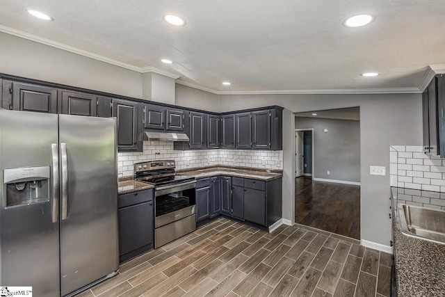 kitchen featuring appliances with stainless steel finishes, dark stone counters, vaulted ceiling, crown molding, and dark hardwood / wood-style floors