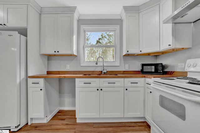 kitchen with wall chimney exhaust hood, white cabinetry, white appliances, and sink