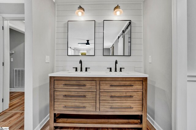 bathroom featuring vanity, wood walls, and wood-type flooring