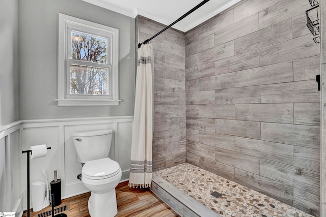 bathroom featuring hardwood / wood-style floors, toilet, walk in shower, and crown molding