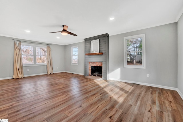 unfurnished living room with a brick fireplace, light hardwood / wood-style flooring, and ornamental molding