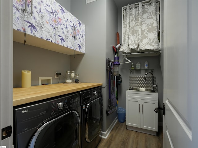 laundry area featuring washer and dryer, cabinets, sink, and dark wood-type flooring