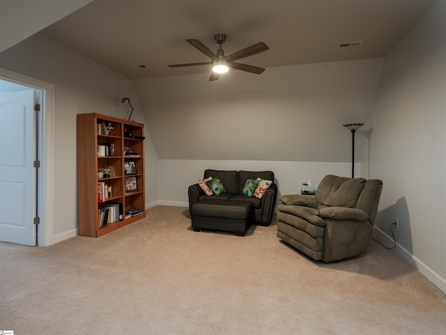 living area featuring light colored carpet, vaulted ceiling, and ceiling fan