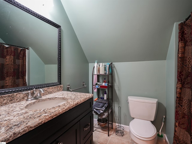 bathroom featuring vanity, tile patterned floors, vaulted ceiling, and toilet