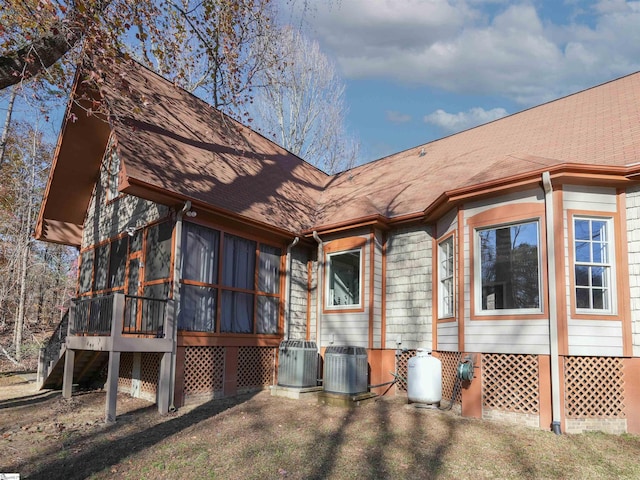 view of side of property with a sunroom and cooling unit