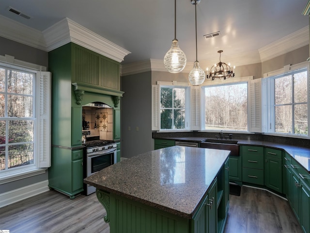 kitchen with appliances with stainless steel finishes, a center island, a wealth of natural light, and green cabinets