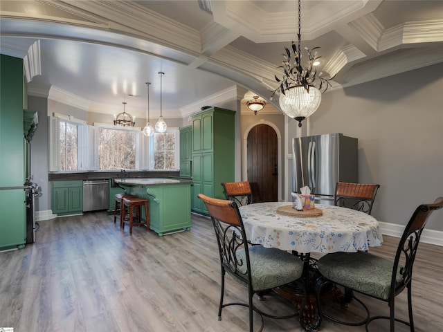 dining area featuring beam ceiling, coffered ceiling, an inviting chandelier, light hardwood / wood-style flooring, and crown molding