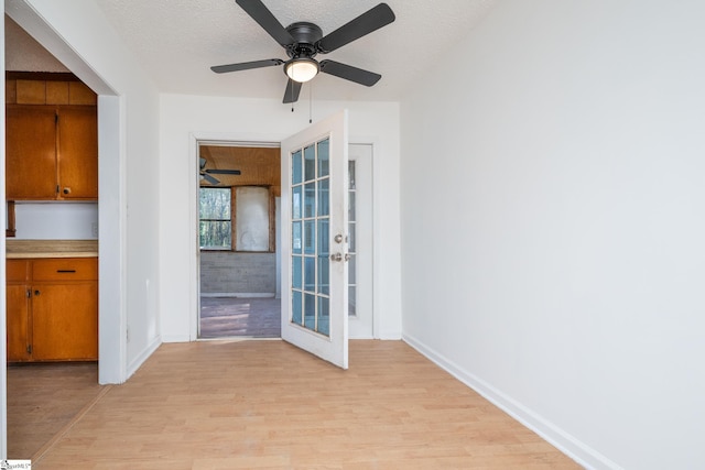 interior space featuring french doors, a textured ceiling, light hardwood / wood-style floors, and ceiling fan