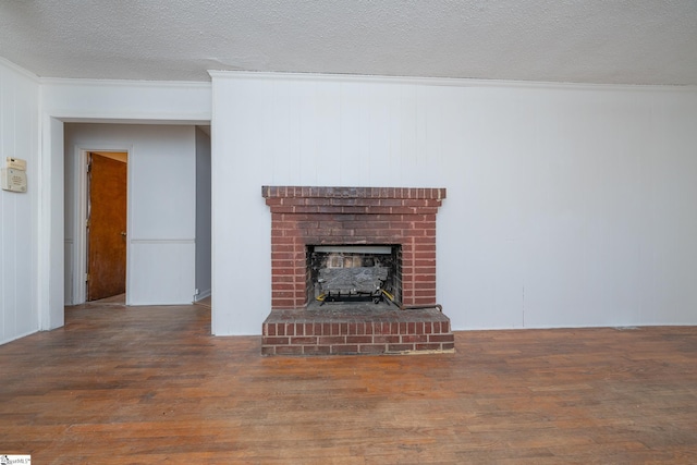 unfurnished living room with a fireplace, dark hardwood / wood-style flooring, and a textured ceiling