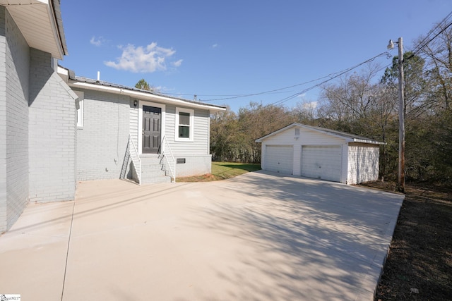 exterior space featuring a garage and an outbuilding