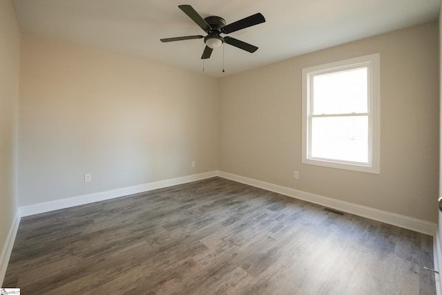 empty room with ceiling fan and dark hardwood / wood-style flooring