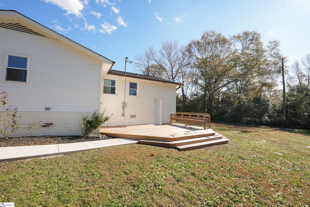 exterior space featuring a deck and a lawn