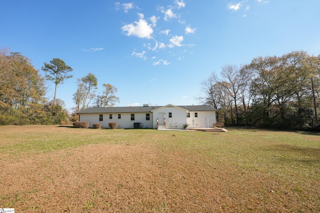 back of property featuring a lawn and central air condition unit