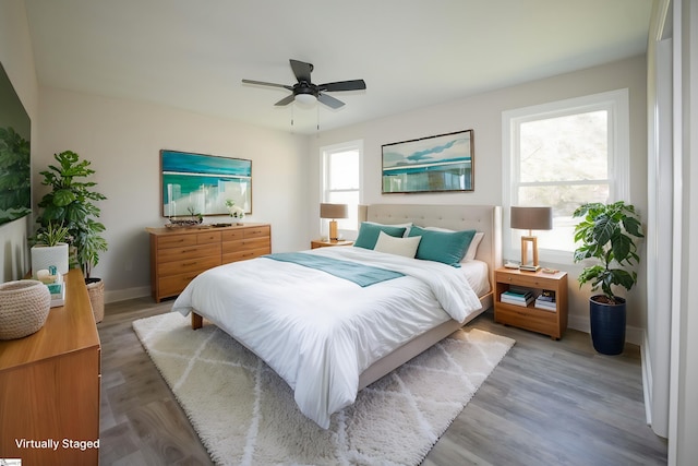 bedroom featuring hardwood / wood-style flooring, multiple windows, and ceiling fan