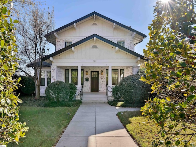 view of front of house with covered porch and a front yard