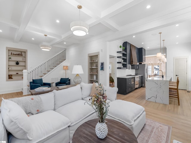 living room with beam ceiling, light hardwood / wood-style flooring, coffered ceiling, and sink