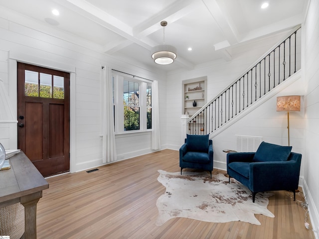 foyer with plenty of natural light, beamed ceiling, and light hardwood / wood-style flooring