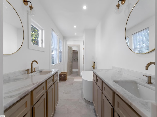 bathroom with tile patterned flooring, a bath, and vanity