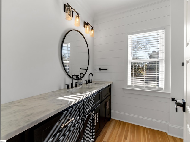 bathroom with hardwood / wood-style floors, vanity, crown molding, and wood walls