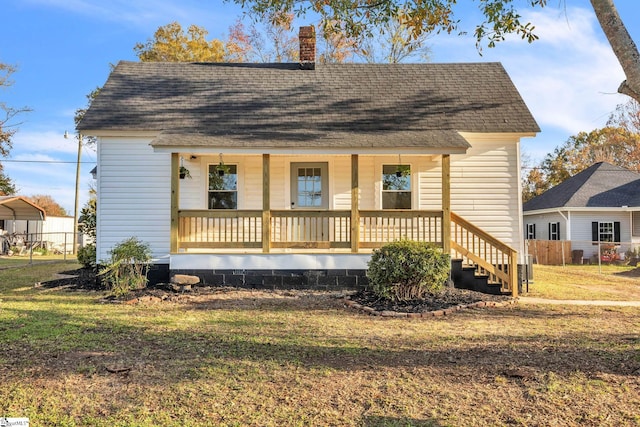 bungalow-style house with covered porch and a front lawn