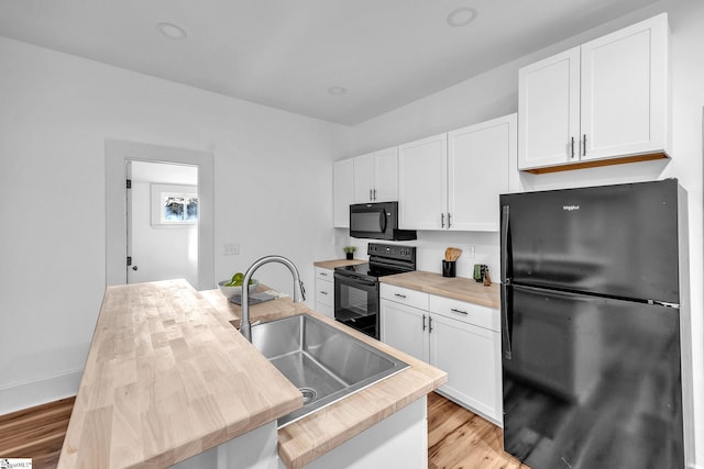 kitchen featuring black appliances, white cabinets, a center island with sink, sink, and light hardwood / wood-style flooring