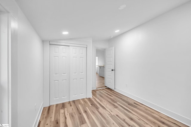 unfurnished bedroom featuring light wood-type flooring and a closet