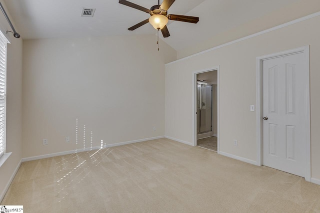 empty room with ceiling fan, light colored carpet, and vaulted ceiling