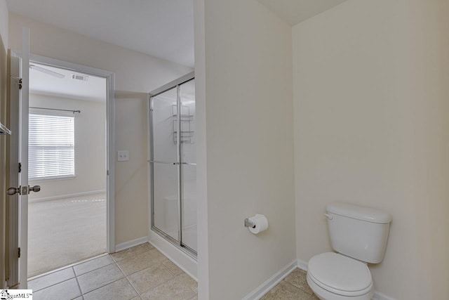 bathroom featuring toilet, tile patterned floors, and an enclosed shower