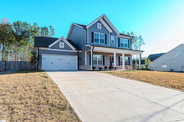 view of front of property featuring a porch, a front yard, and a garage