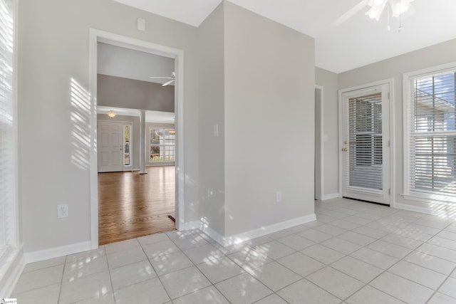 tiled empty room featuring ceiling fan