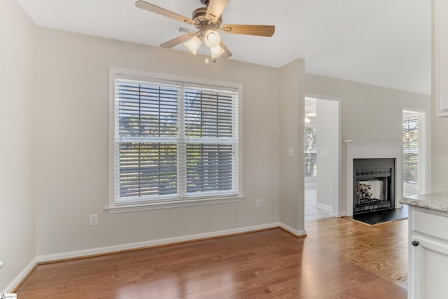 unfurnished living room with ceiling fan and light hardwood / wood-style floors