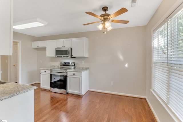 kitchen featuring white cabinetry, light hardwood / wood-style flooring, ceiling fan, and stainless steel appliances