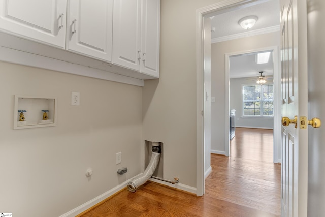 laundry room featuring hookup for a gas dryer, cabinets, ornamental molding, and light hardwood / wood-style flooring