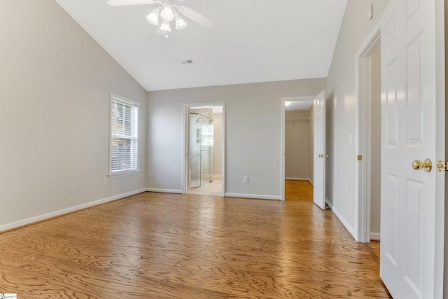 empty room featuring ceiling fan, vaulted ceiling, and light wood-type flooring