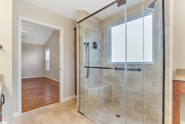 bathroom featuring wood-type flooring, an enclosed shower, and lofted ceiling