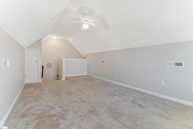 additional living space featuring ceiling fan, light colored carpet, and vaulted ceiling