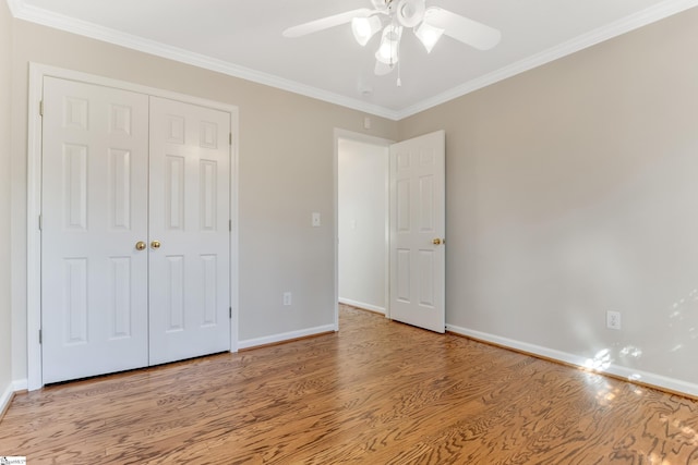 unfurnished bedroom with a closet, ceiling fan, crown molding, and light wood-type flooring