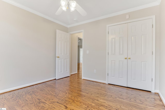 unfurnished bedroom featuring ceiling fan, light hardwood / wood-style floors, ornamental molding, and a closet