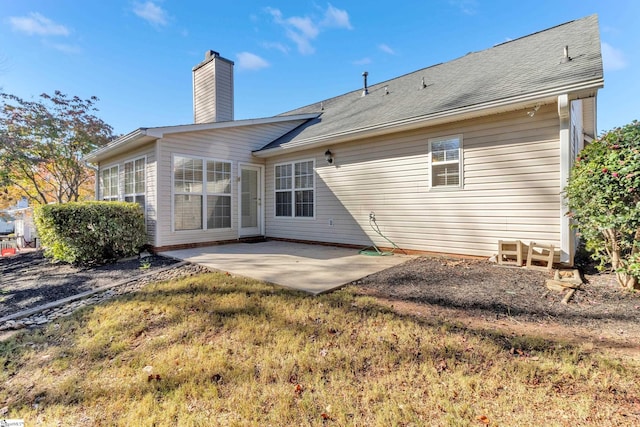 rear view of house with a patio area and a lawn