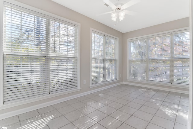 unfurnished sunroom featuring ceiling fan and a healthy amount of sunlight